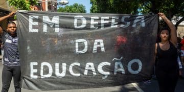 People are protesting, with banners, against the cuts in educati