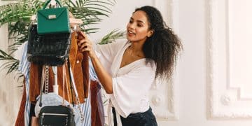 young-woman-looking-clothes-purses-rack-while-standing-home
